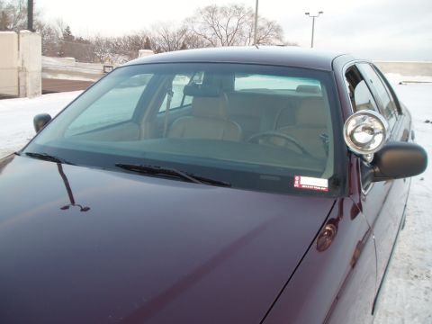 1999 Ford Crown Victoria - A dark purple Ford Crown Victoria with a spotlight is parked in a snowy area.