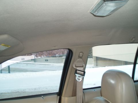 1999 Ford Crown Victoria - View from inside a car, looking out the window at a winter landscape. The interior shows the headliner and a seatbelt.