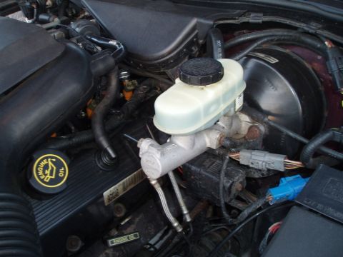 1999 Ford Crown Victoria - Close-up view of a vehicle's engine bay, focusing on the brake system components.