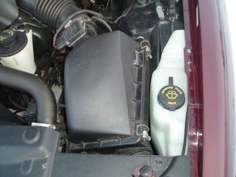 1999 Ford Crown Victoria - Close-up view of the engine bay, highlighting the air intake system and the washer fluid reservoir.