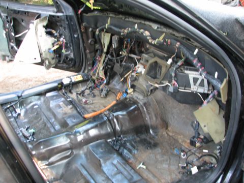 1999 Ford Crown Victoria - Gutted sedan interior shot through the door opening: seats, carpet and dash pad removed down to bare painted floor pan and transmission tun…