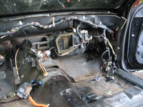 1999 Ford Crown Victoria - Interior of a car with dashboard removed, exposing wiring harness and components.