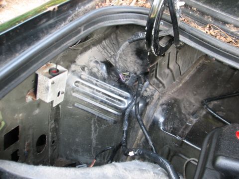 1999 Ford Crown Victoria - Looking down into a stripped front footwell through the open door of a black car, with carpet, seats and kick panels removed to show the ba…