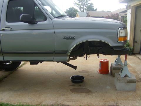 1995 Ford Bronco - This 1995 Ford Bronco is elevated on jack stands for maintenance, with an oil pan visible below.
