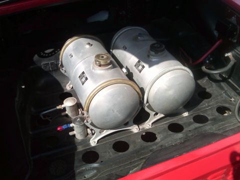 1988 Ford Bronco - Two large cylindrical tanks are mounted in the cargo area of a red vehicle, possibly for fuel or air storage.
