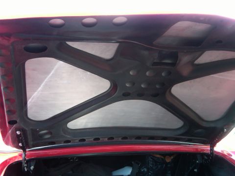 1988 Ford Bronco - The underside of a car's hood shows structural bracing and sound deadening material.