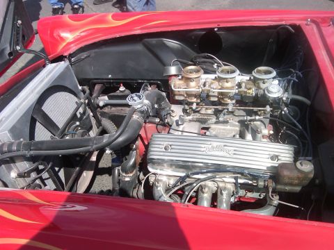 1988 Ford Bronco - Engine bay view showing a V8 engine with dual carburetors and flame decals on the fender.