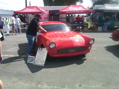 1988 Ford Bronco - A red 1955 Ford Thunderbird with flame graphics is displayed with a sign detailing its history.