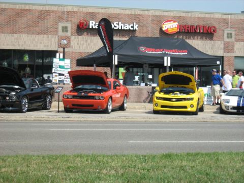 1988 Mercury Grand Marquis - Cars on display at an outdoor event in front of retail stores.