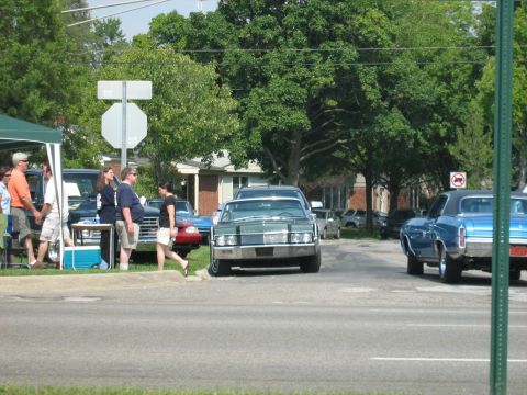 1988 Mercury Grand Marquis - A green vintage sedan is parked on the street, with a blue car to its right.