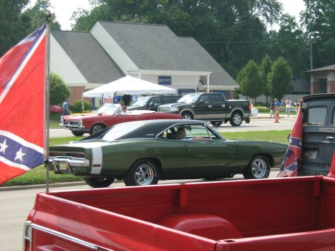 1988 Mercury Grand Marquis - A classic green Dodge Charger is parked at an outdoor event, with other vehicles and a flag visible.