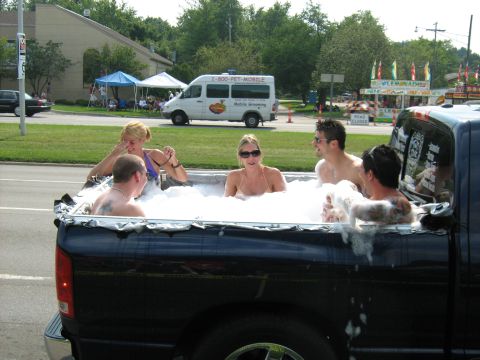 1988 Mercury Grand Marquis - People enjoy a bubble bath in the bed of a black pickup truck during a summer event.