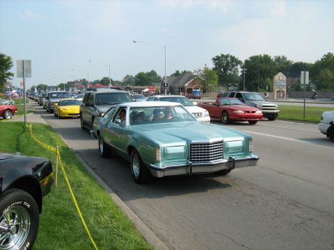 1988 Mercury Grand Marquis - A light blue coupe with a white roof cruises down the road in a line of cars during a 2009 event.