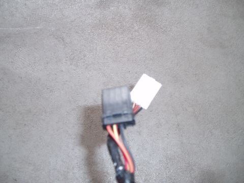 2003 Ford Crown Victoria - Close-up of a black multi-pin automotive wiring connector with a blank white label tag attached, red, orange and black wires running out of…