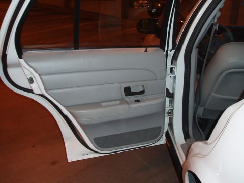 2003 Ford Crown Victoria - Close-up view of the interior door panel and the open door of a vehicle.