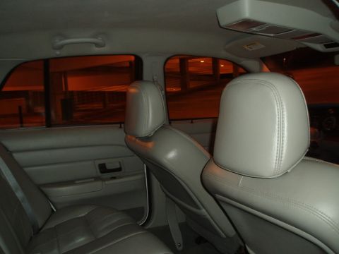 2003 Ford Crown Victoria - Rear interior view of a sedan, showing gray leather seats and door panels.