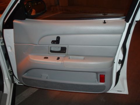 2003 Ford Crown Victoria - Interior door panel of a car, showing window controls and storage compartment.
