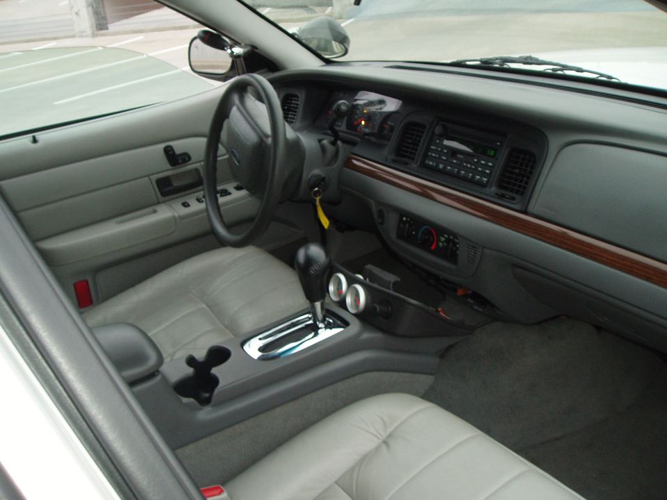 Gray leather Ford sedan interior with floor-shift automatic conversion and console gauges