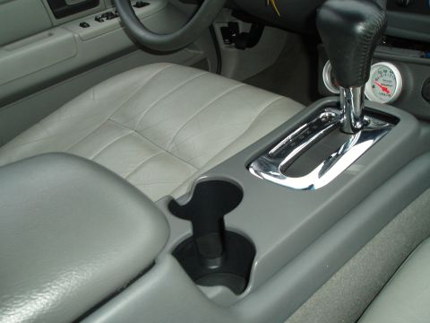 2003 Ford Crown Victoria - Interior view showing the center console, gear shifter, and a voltmeter gauge, with gray leather seats.
