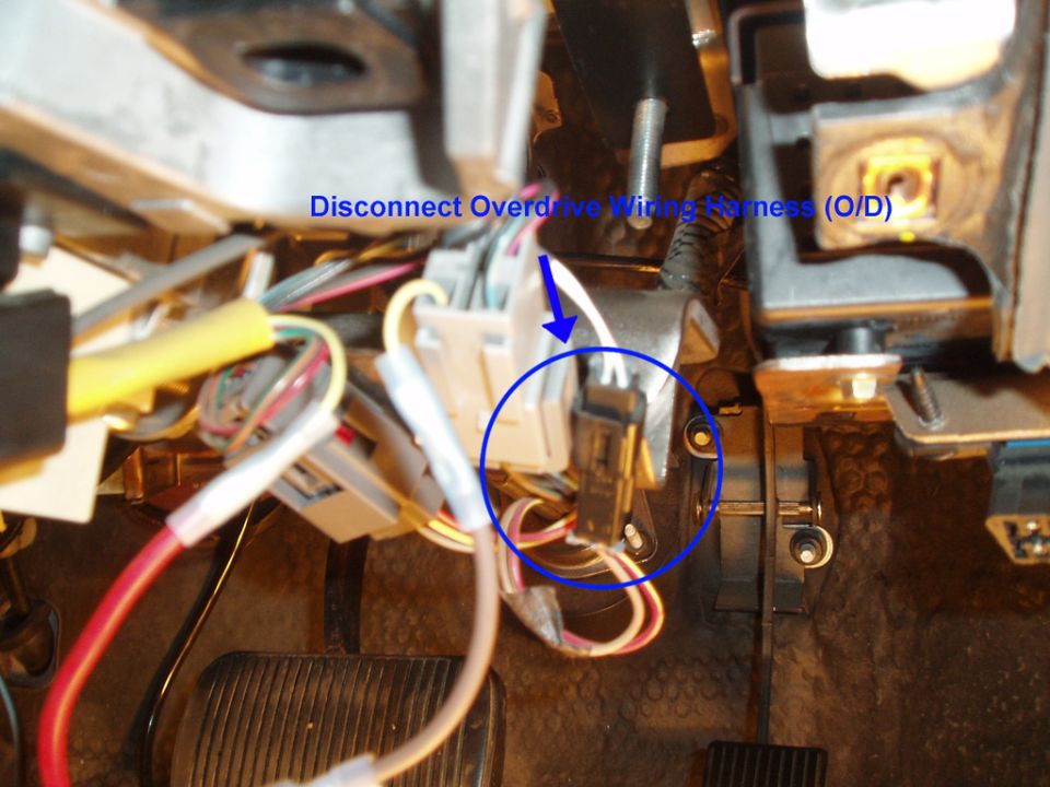 The column shifter is now free, you will no longer need that or any of the other parts you removed, including the old column interlock and brackets. The last part is to disconnect the overdrive harness.