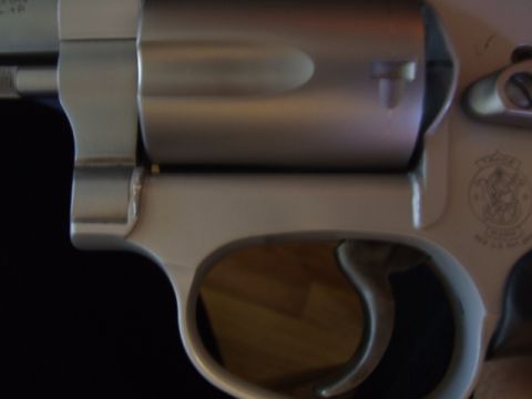2002 Jeep TJ - A detailed view of a revolver, showing its cylinder, trigger, and a portion of the frame with the manufacturer's emblem.