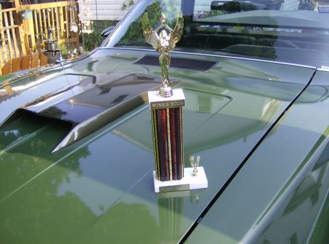 1970 Ford Ranchero - A trophy sits on the hood of a green 1970 Ford Ranchero, which has a prominent hood scoop.