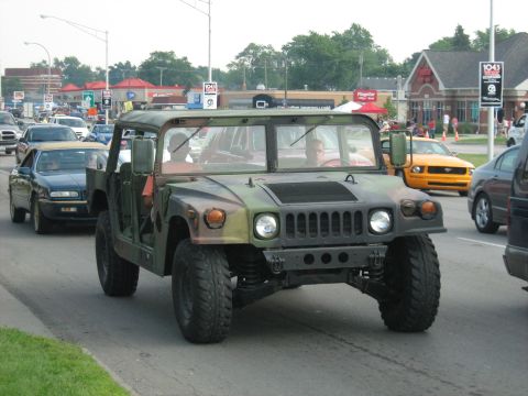 1988 Mercury Grand Marquis - Humvee driving in traffic on a sunny day, with other cars visible.