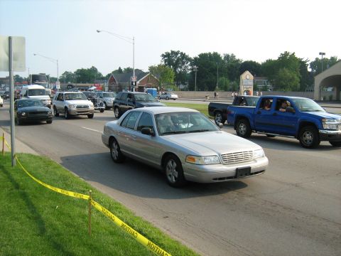 1988 Mercury Grand Marquis - A silver sedan is seen in traffic on a sunny day, with other vehicles around it.