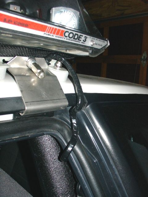 1993 Ford Mustang - Close-up of wiring for a Code 3 Public Safety Equipment light bar, attached to a vehicle's roof.