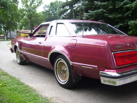 1979 Ford Thunderbird - Rear quarter view of a maroon coupe with a vinyl roof and gold wheels.