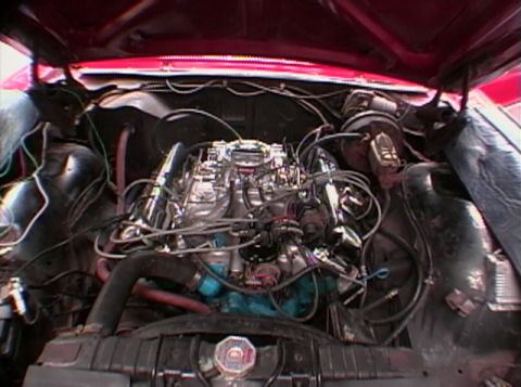 1967 Ford Galaxie - The engine compartment of a car is shown with the hood open, revealing the V8 engine and associated components.