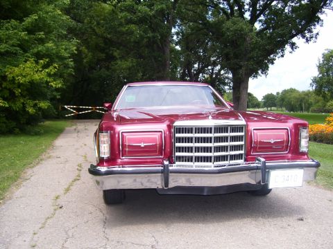 1979 Ford Thunderbird - A red 1977 Ford Thunderbird is parked on a gravel driveway with trees and a gate in the background.