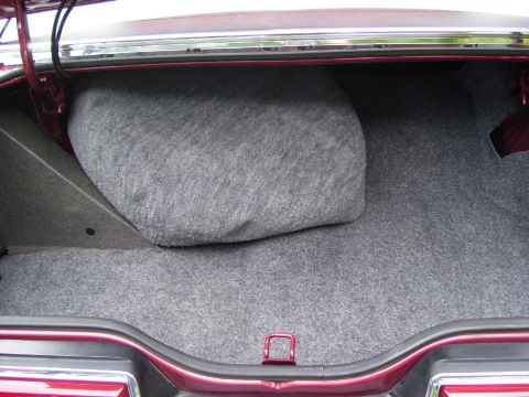 1979 Ford Thunderbird - The interior of a car trunk is shown, covered in grey carpeting.