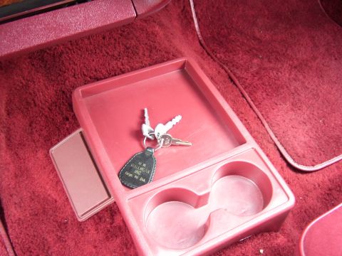 1979 Ford Thunderbird - Interior console with keys and cup holders. The key fob indicates the vehicle may be from H.W. Wallwork Inc. in Fargo, North Dakota.
