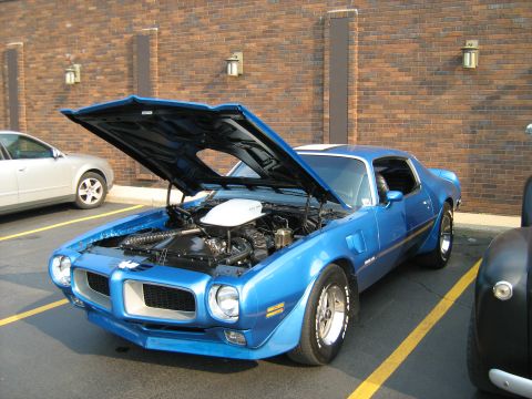 1988 Mercury Grand Marquis - A blue 1970s muscle car is parked with its hood open, revealing the engine bay.
