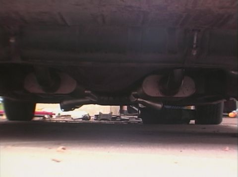 1967 Ford Galaxie - The underside of a vehicle is shown, focusing on the dual exhaust system and mufflers.