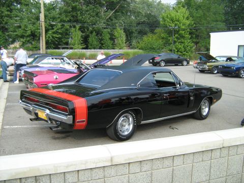 1988 Mercury Grand Marquis - Black 1970 Dodge Charger R/T with orange stripe parked at a car show.