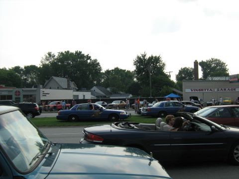 1988 Mercury Grand Marquis - Outdoor car event with multiple police cruisers and civilian vehicles visible near Vinsetta Garage.
