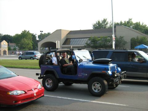 1988 Mercury Grand Marquis - A blue Jeep Wrangler is parked next to other vehicles during a car show.