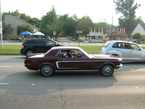 1988 Mercury Grand Marquis - Maroon 1967 Ford Mustang coupe seen driving on a street with other vehicles.
