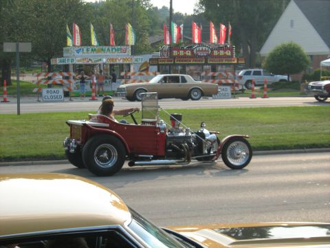 1988 Mercury Grand Marquis - A custom hot rod with a powerful engine cruises by food vendors at an outdoor event.
