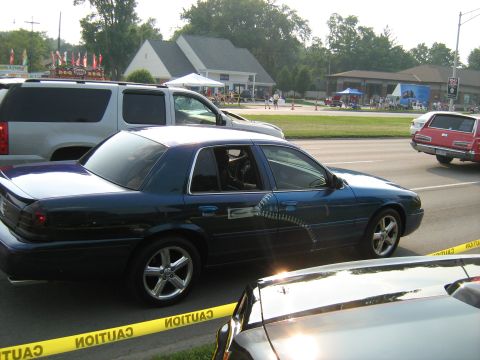 1988 Mercury Grand Marquis - Blue sedan with custom graphics is seen at an outdoor event with other vehicles present.