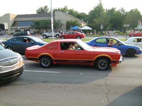 1988 Mercury Grand Marquis - A red coupe with a 'Road Runner' decal is seen in traffic alongside other vehicles.
