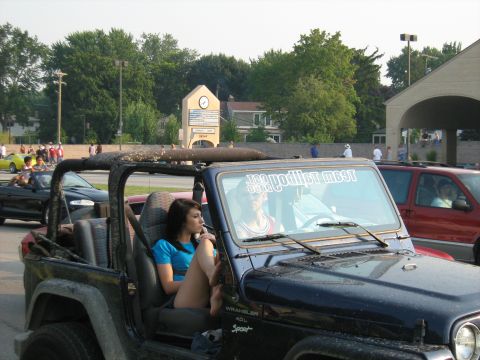 1988 Mercury Grand Marquis - Two women sit in a Jeep Wrangler, parked in a lot with other vehicles visible.
