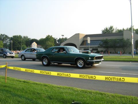 1988 Mercury Grand Marquis - Customized 1969 Ford Mustang Mach 1 with a prominent hood scoop is seen on the road.