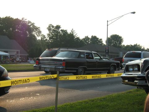 1988 Mercury Grand Marquis - A black 1988 Lincoln Town Car sedan is seen from the side, with caution tape stretched across the road in front of it.