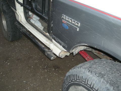 1991 Ford Bronco - The side of a 1991 Ford Bronco is visible, the 'Bronco' and 'XLT' badging on the fender.