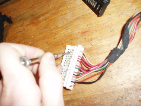 2003 Ford Crown Victoria - pull out the plastic taps on each side of the harness and use a small screw driver at and angle to free the pins.