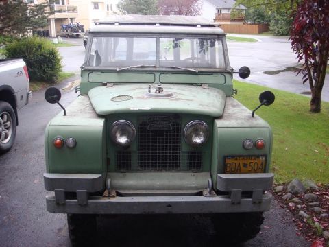 1967 Land Rover Land Rover - Front view of a green Land Rover Series IIA, showing its distinctive grille and headlights.