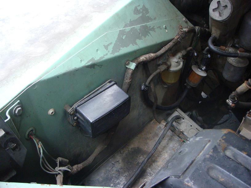 Close-up of engine bay showing fuel filter, wiring, and a black box